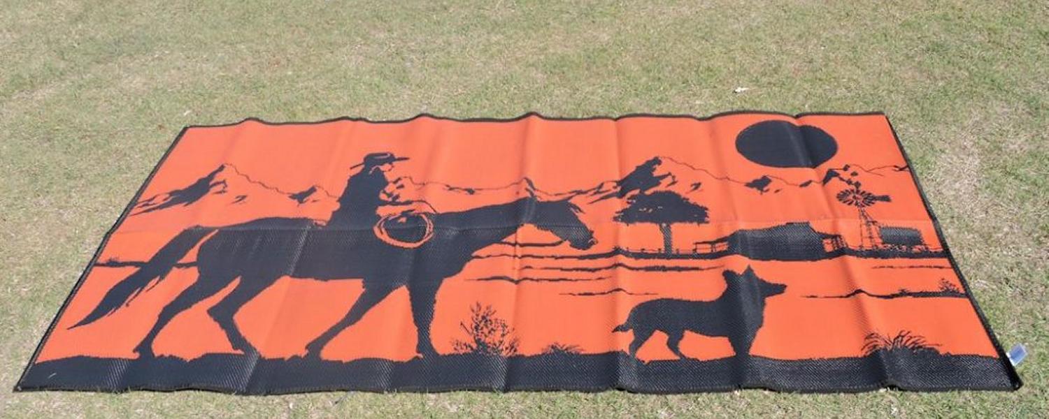 Jawa Off Road Camper Trailers camping mat for outside caravan. "Riding home" is an orange and black mat with the image of a dog followed by a man on his horse in the Australian bush. Available in Sunshine Coast Queensland.