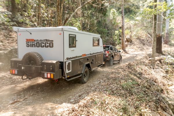 Jawa Sirocco towed by four wheel drive on off road mountain track. Family hybrid caravan on tough landscape. See our camper trailers at our Sunshine Coast Queensland showroom.