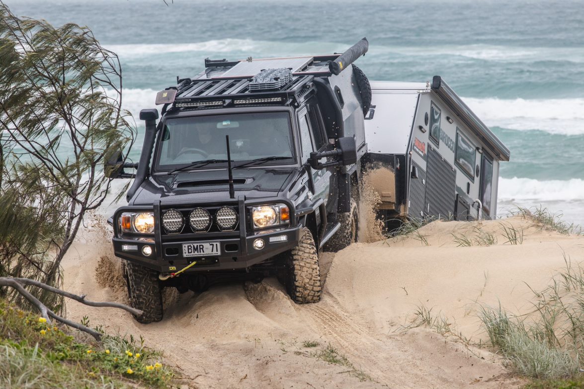 Jawa Sirocco impressively towed by four wheel drive over sand dune on a beach. Family hybrid caravan for sale at Jawa Off Road Camper Trailers in the Sunshine Coast Queensland.