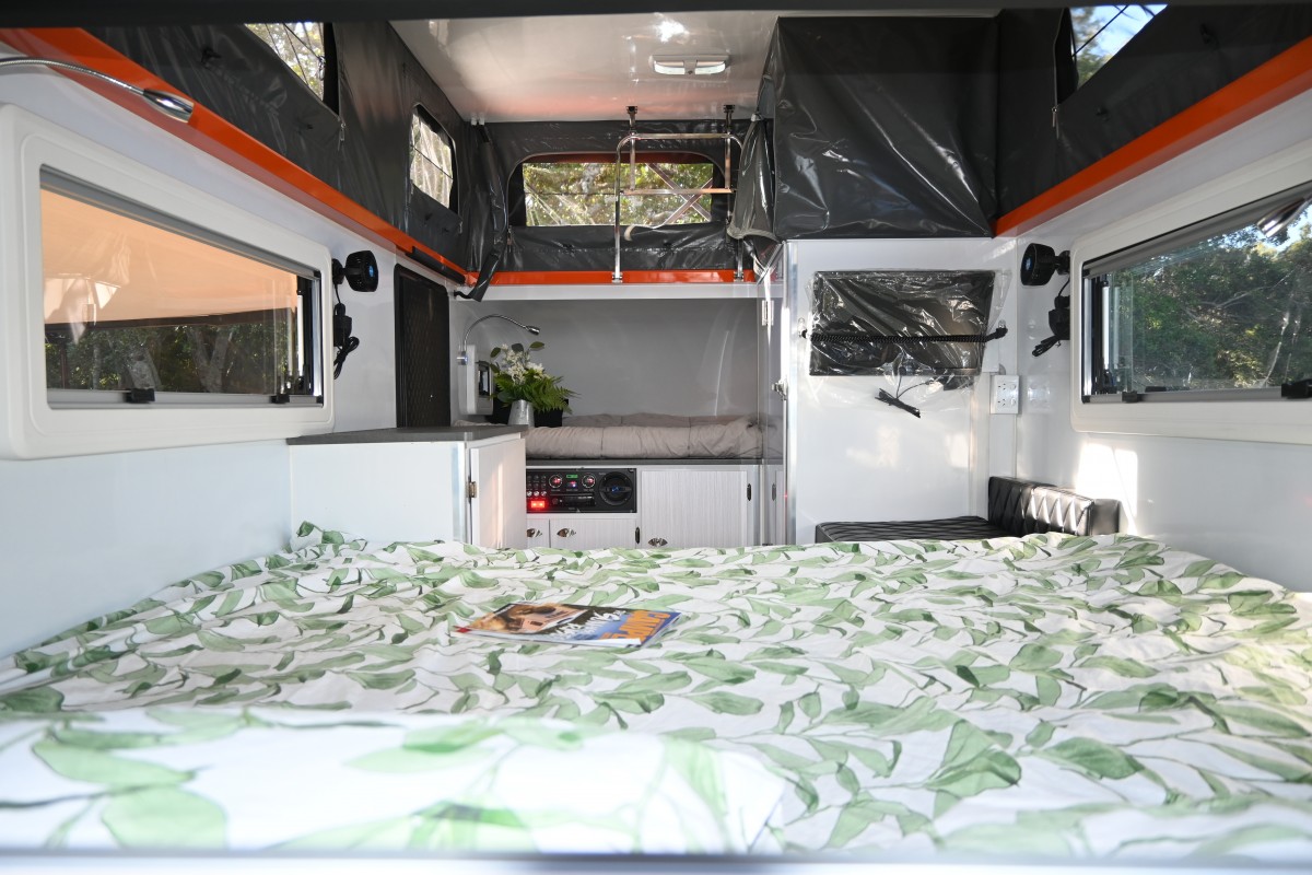 View from the inside of Jawa Lowdown 13 Hybrid Caravan with roof popped out. Spacious interior of off road camper trailer with queen bed, oversize bunk, internal ensuite and seating. Buy in Sunshine Coast Queensland.