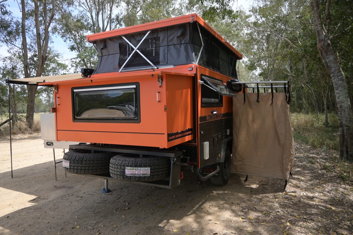 Jawa Lowdown 13 Cupboard low hybrid poptop off road camper with lots of storage perfect for adventuring couples and storing in standard garage, pictured from behind showing back and poptop extended and Kickass show tent attached to the around the back of the camper.